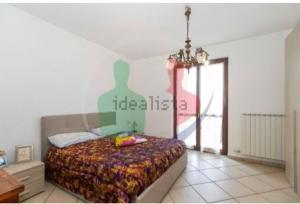 a bedroom with a bed and a chandelier at la casa di Camilla in Volvera