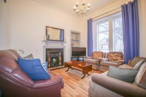 a living room with leather furniture and a fireplace at Telford Rd 5 Bedroom House Inverness in Inverness
