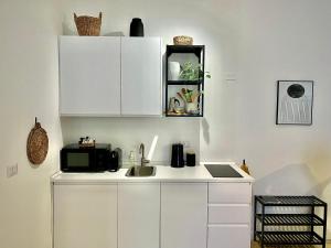 a kitchen with white cabinets and a sink at Milano Modern Home in Milan