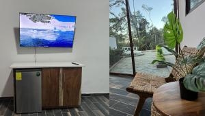 a living room with a flat screen tv on a wall at Termales la Montaña “ Suite Jr Aire de Montaña 5” in Ahuachapán