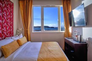 a bedroom with a bed and a large window at Muthu Oban Regent Hotel- Refurbished in Oban