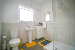 a bathroom with a toilet and a sink and a shower at Telford St 4 Bedroom House Inverness in Inverness