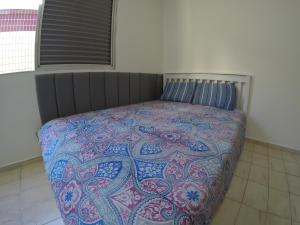 - une chambre avec un lit et une couverture colorée dans l'établissement A melhor localização da PG. Com ar cond.!, à Praia Grande