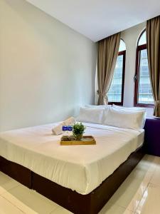 a bedroom with a bed with a tray on it at Swing & Pillows - KL Masjid India formerly known as Mountbatten Hotel Kuala Lumpur in Kuala Lumpur