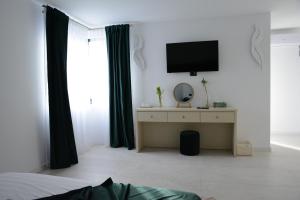 a bedroom with a tv and a desk with a mirror at Complex Braniște in Drăgăşani