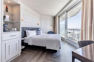 ein Hotelzimmer mit einem Bett und einem großen Fenster in der Unterkunft Le Capitole Hotel in Québec