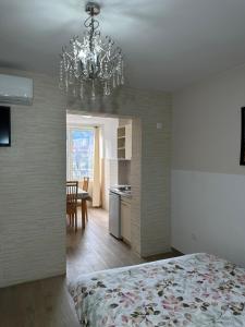 um quarto com uma cama e um lustre em Apartmani Simona em Budva