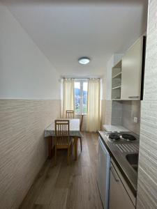 - une cuisine avec une table, une table et des chaises dans l'établissement Apartmani Simona, à Budva