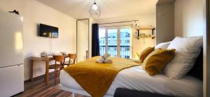 um quarto com uma cama com um cobertor amarelo em Le Ciel: Studio 30m2, sans vis-à-vis, RERB à 12min em Bourg-la-Reine