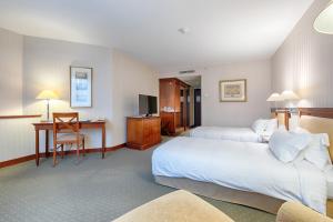 Cette chambre comprend deux lits et un bureau. dans l'établissement Evergreen Laurel Hotel, à Levallois-Perret