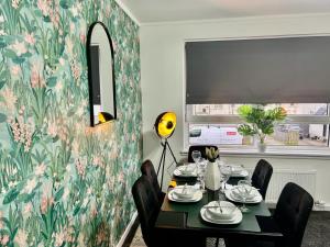 a dining room with a table and a floral wallpaper at Aitkenhead house by Klass Living in Coatbridge