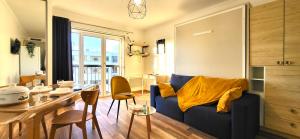 uma sala de estar com um sofá azul e uma mesa em Le Ciel: Studio 30m2, sans vis-à-vis, RERB à 12min em Bourg-la-Reine