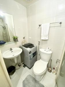 a white bathroom with a toilet and a sink at Cozy Studio with SM Jazz Mall "12 floor" in Manila