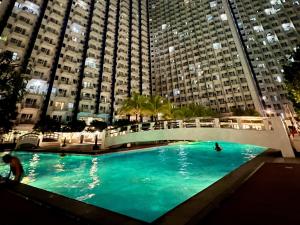 a large swimming pool in front of tall buildings at Cozy Studio with SM Jazz Mall "12 floor" in Manila