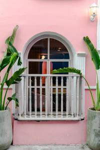 een roze huis met een witte leuning en een raam bij Sublime Hotel Boutique Cartagena in Cartagena