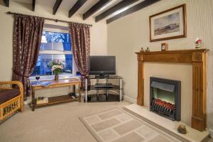a living room with a fireplace and a television at Mynydd Crwn Bach Clynderwen in Clynderwen