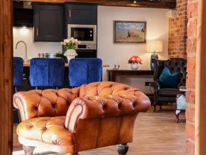 ein braunes Ledersofa im Wohnzimmer in der Unterkunft Beth's Cottage in Malton