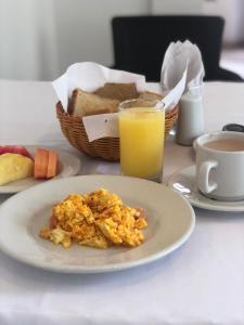 una mesa con un plato de comida y un vaso de zumo de naranja en San Martin Cartagena, en Cartagena de Indias