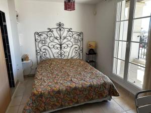 ein Schlafzimmer mit einem Bett in einem Zimmer mit Fenstern in der Unterkunft Marina 4 adultes 4 enfants piscine commune in Aigues-Mortes