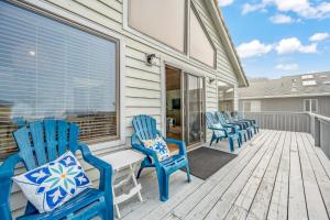 um grupo de cadeiras azuis sentadas num alpendre em Salt & Serenity Large home for seven near beach access with private spa! em Lincoln City