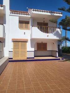 a white house with yellow doors and a tile driveway at BERJA33 in Roquetas de Mar
