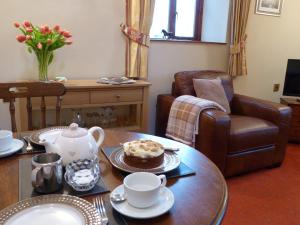 a living room with a table with a cake and a chair at Shire Cottage Devils Bridge in Yspytty Cynfyn