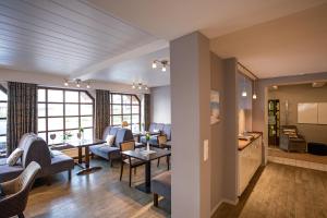 a living room with chairs and tables and a kitchen at Lieblingsplatz Seedeich in Grömitz