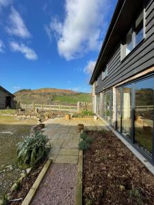 a house with a stone walkway next to a yard at The Granary in Kington