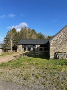 an old stone barn with a black roof at The Granary in Kington