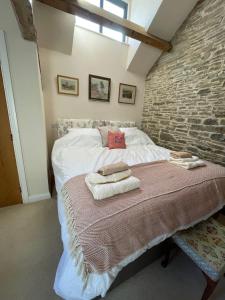 una camera da letto con un letto e asciugamani di The Granary a Kington