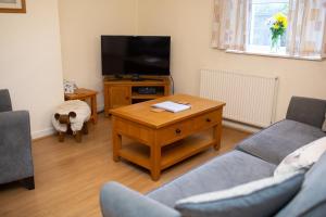 - un salon avec un canapé et une télévision dans l'établissement Soar Cottage Aberystwyth, à Aberystwyth