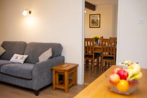 a living room with a gray couch and a table at Soar Cottage Aberystwyth in Aberystwyth