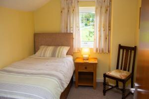 a bedroom with a bed and a table with a lamp at Soar Cottage Aberystwyth in Aberystwyth
