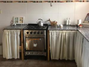een keuken met een fornuis en een aanrecht met gordijnen bij Finca, La Joya in Ciudad Lujan de Cuyo