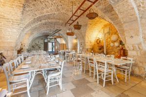 un comedor con mesas y sillas blancas en Agriturismo Masseria Carrone, en Carovigno