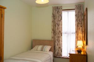 a bedroom with a bed and a window with curtains at Townhouse Aberystwyth in Aberystwyth