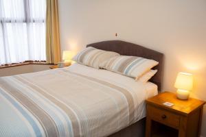 a bedroom with a bed with two lamps on a table at Townhouse Aberystwyth in Aberystwyth +16 photos