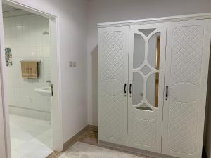 ein Bad mit einer Dusche und einem weißen Schrank in der Unterkunft Arabian Nights Nook in Muscat