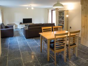 a living room with a table and chairs and a couch at Ty Ceiniog New Quay in Cross Inn