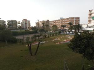 einen Park mit Palmen und Gebäuden in einer Stadt in der Unterkunft Edificio Salou Beach, la Pineda, Vilaseca in La Pineda