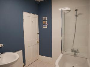 ein Badezimmer mit Badewanne, Waschbecken und Dusche in der Unterkunft Fishermans Cottage in Portland + 30 Fotos