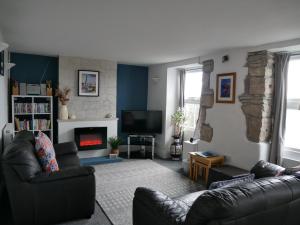 a living room with a couch and a fireplace at Fishermans Cottage in Portland