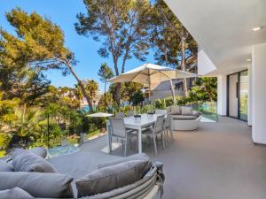 an outdoor patio with a table and chairs at Villa cala Vinyas in Cala Vinyes