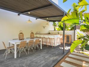 a patio with a white table and chairs at Villa cala Vinyas in Cala Vinyes