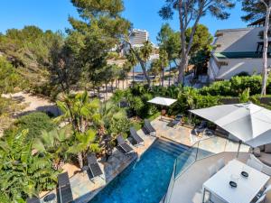 vista aerea su una piscina del resort con sedie e ombrelloni di Villa cala Vinyas a Cala Vinyes