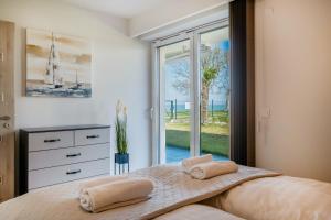 ein Schlafzimmer mit einem Bett mit zwei Handtüchern darauf in der Unterkunft MF Sunset Beach77 Premium Apartment in Siófok