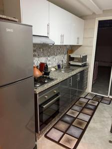 cocina con nevera de acero inoxidable y fregadero en Luxurious 2 BD apartment in the Heart of Kenitra, en Kenitra