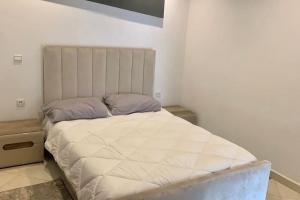 1 dormitorio con 1 cama grande con colchón blanco en Luxurious 2 BD apartment in the Heart of Kenitra, en Kenitra