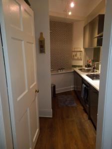 a kitchen with a white door and a stove top oven at 1 Bedrooms Flat in Central Edinburgh Haymarket, Heart of Edinburgh Flat Sleeps 4 in Edinburgh