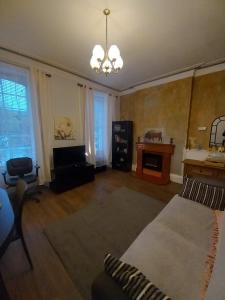 a living room with a couch and a chandelier at 1 Bedrooms Flat in Central Edinburgh Haymarket, Heart of Edinburgh Flat Sleeps 4 in Edinburgh